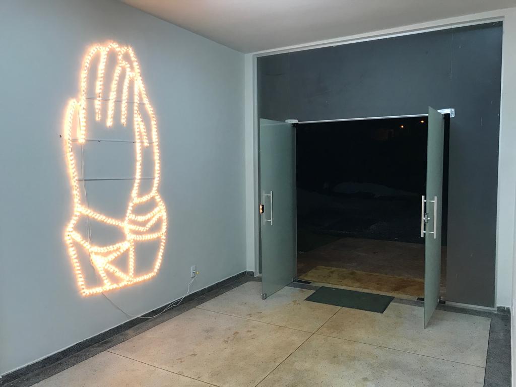Entrada do templo com mãos em oração iluminadas